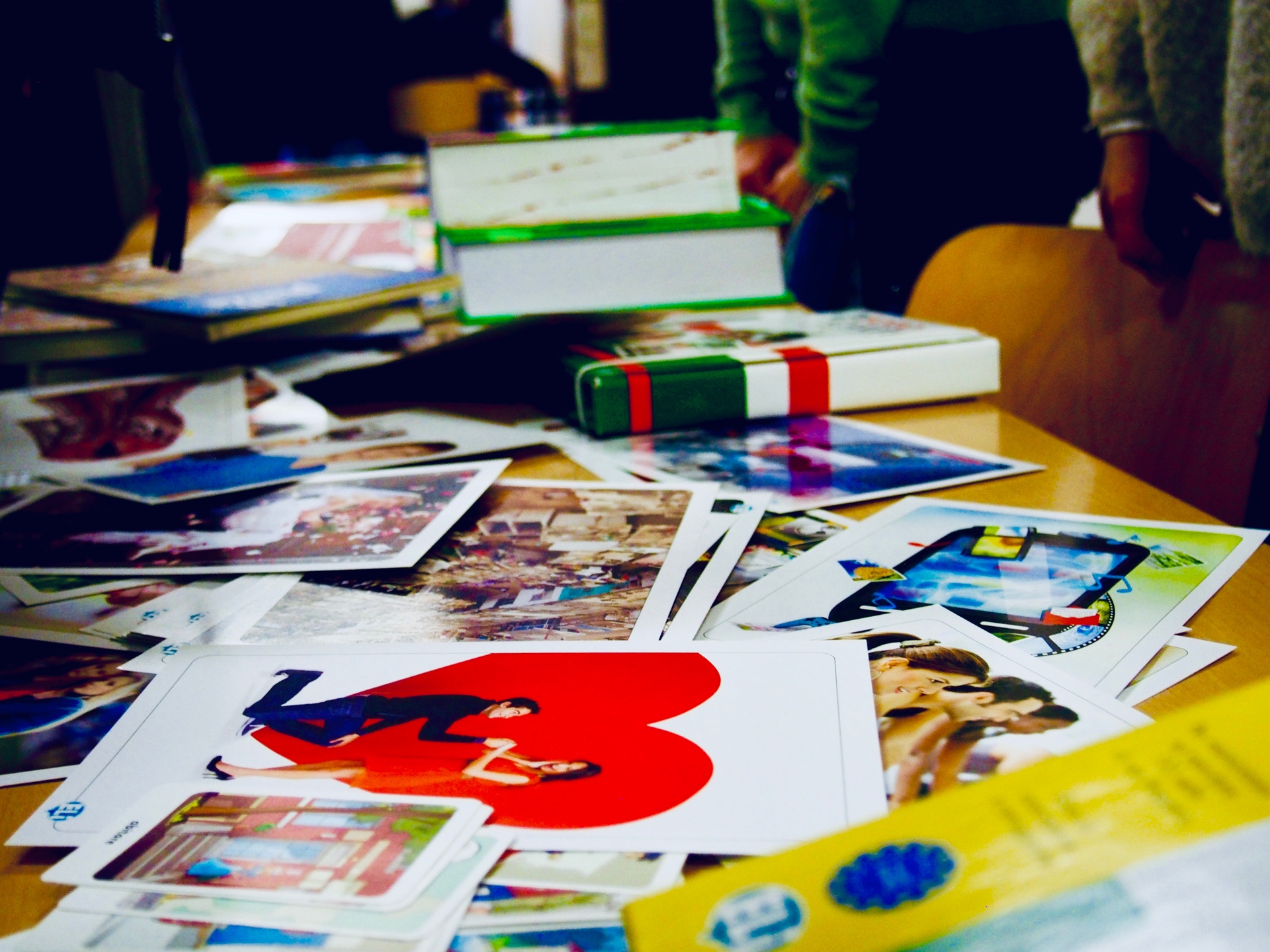 Tisch voller Fotos, Bücher und Bastelmaterial während einer Projektarbeit