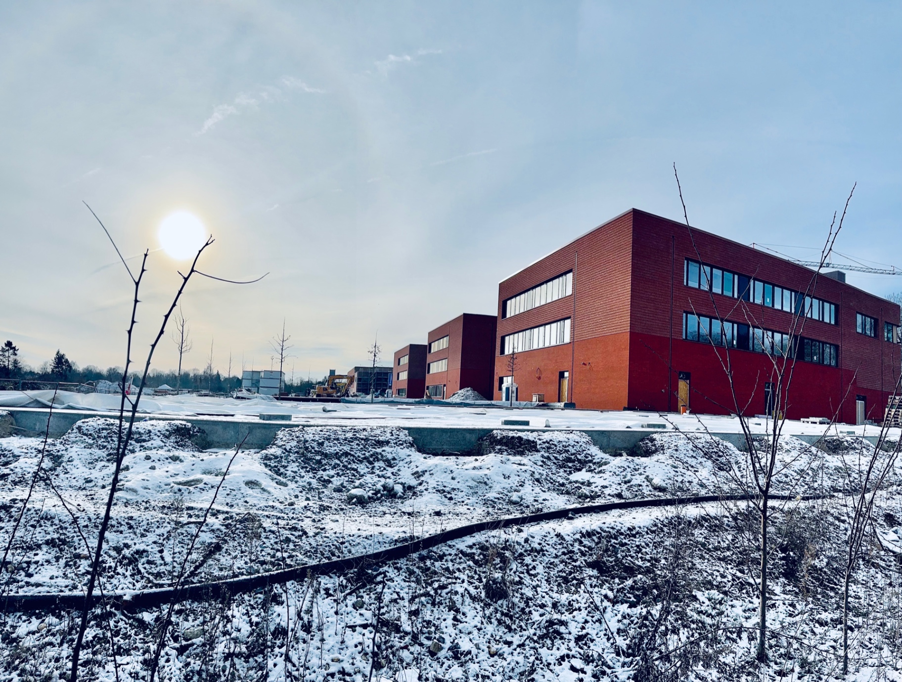Der Neubau des Luisen-Gymnasiums: ein dreigeschossiger Klinkerbau hinter der verschneiten Baustellenfläche